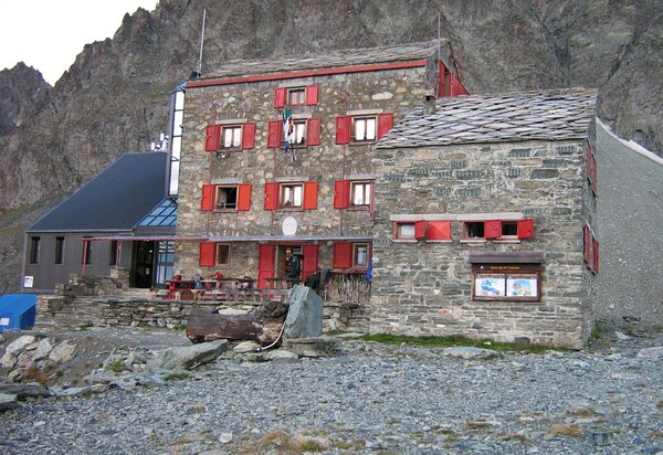 la struttura del rifugio con muri in pietra e infissi rossi